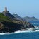 A stone tower perched on a coastal mountain